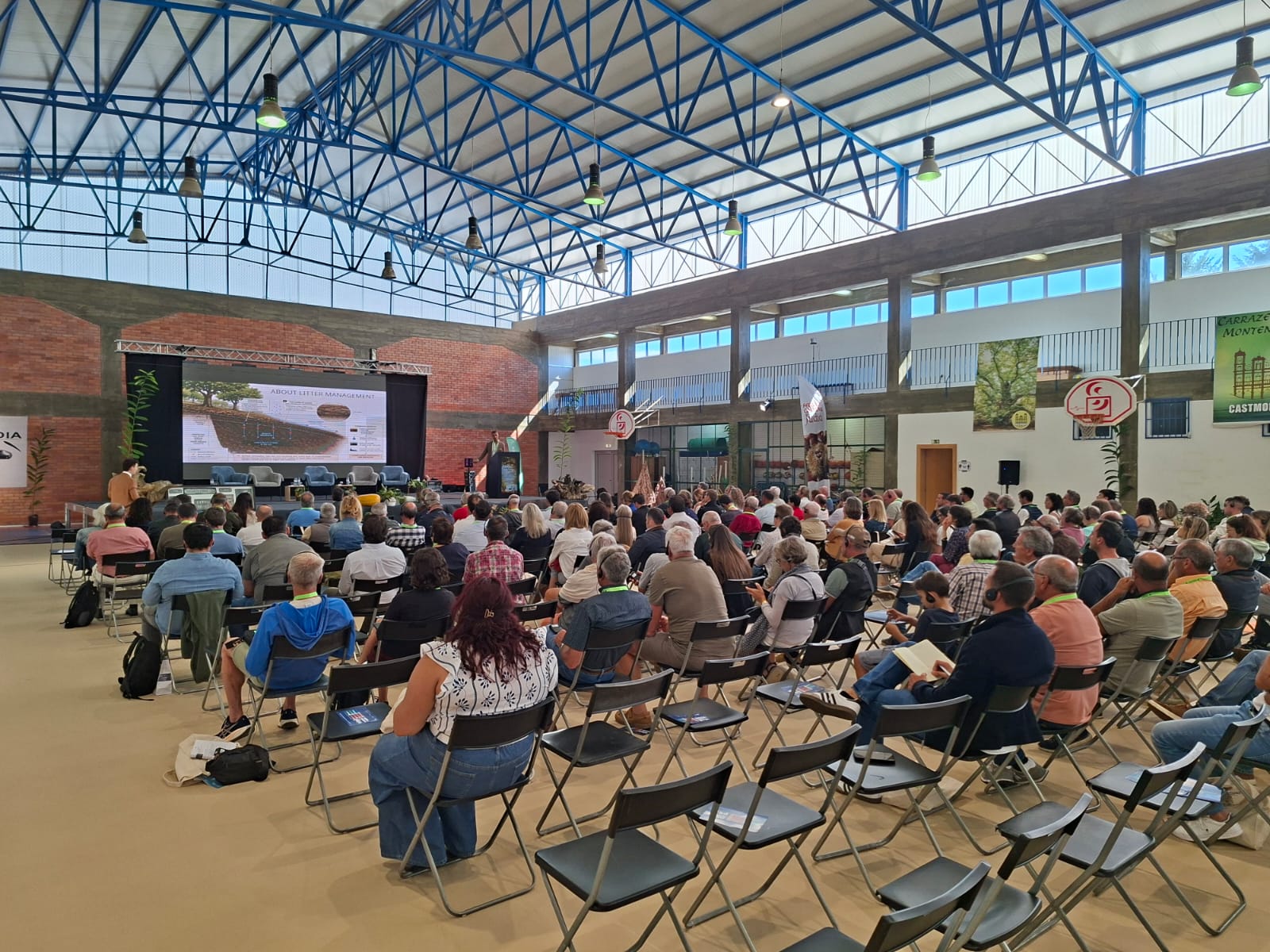 Asistentes escuchan una ponencia en un pabellón cubierto